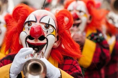 Colorful clown group playing the trumpet at Basel fasnacht festival.