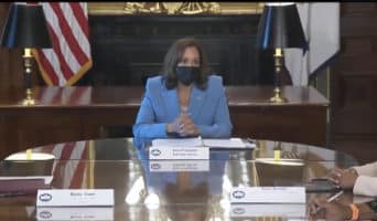 President She/Her Wearing a Blue Suit at the Table